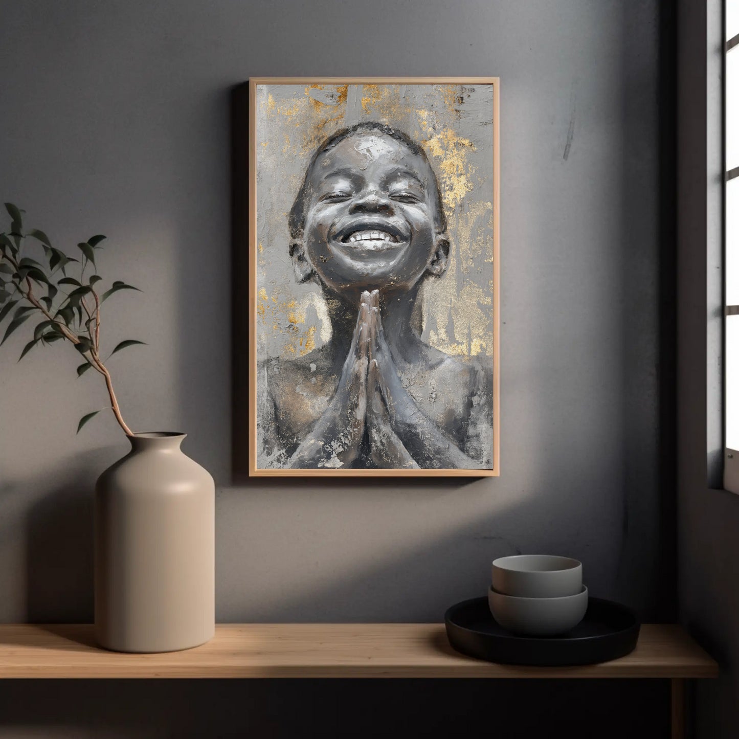 a framed painting of a smiling person with their hands clasped together, hanging on a wall above a wooden shelf with a vase and bowls.