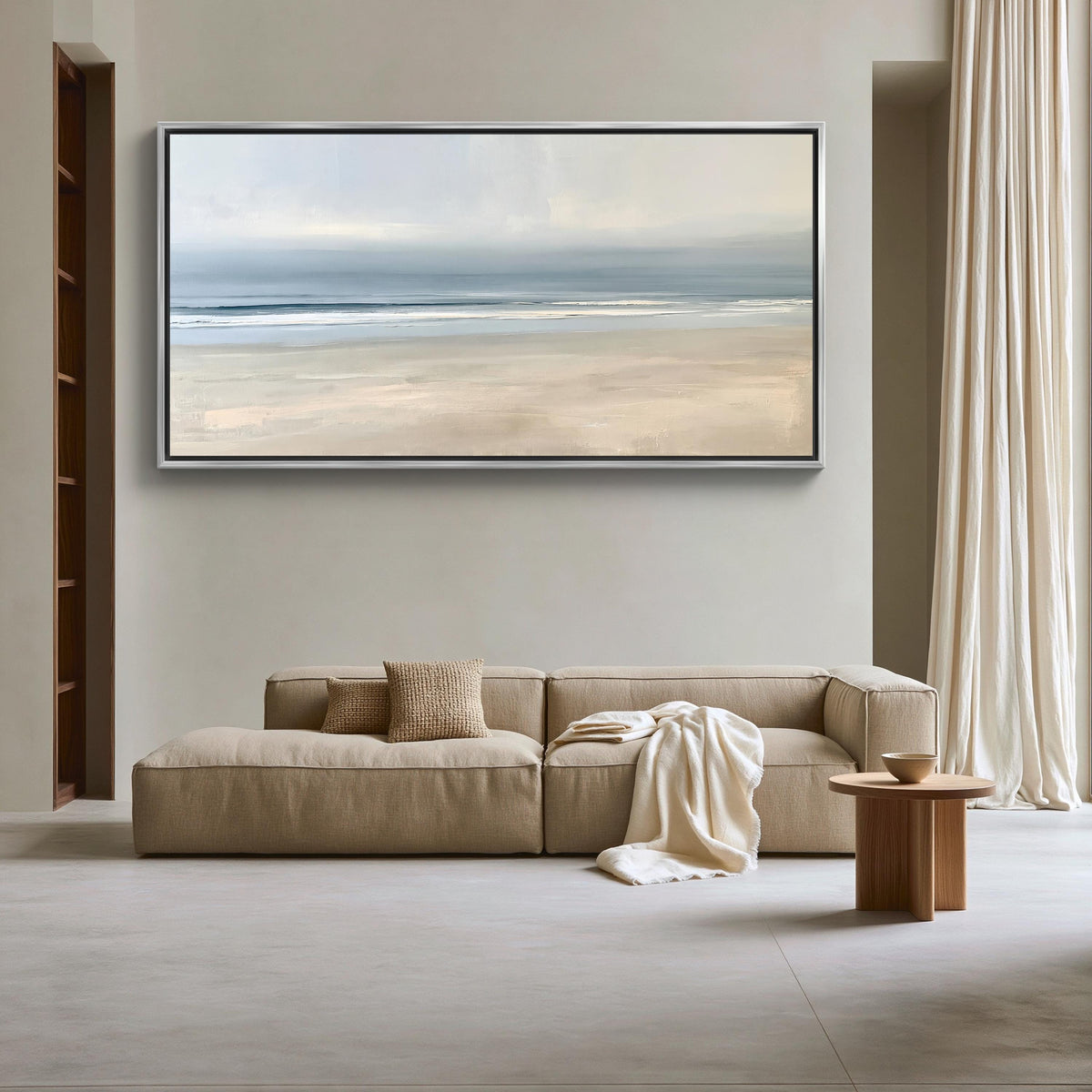 Calm minimalist beach canvas wall art, large, framed painting of a beach scene hanging on a wall above a beige sofa with a