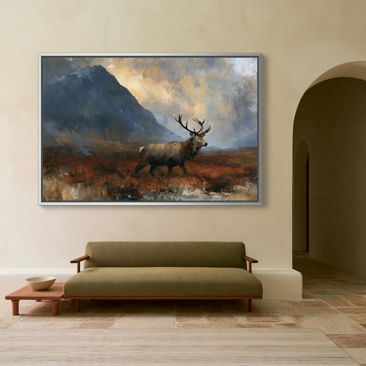 Red stag in the Highlands canvas wall art, large painting of a deer in a field, hanging on a wall above a green sofa in a