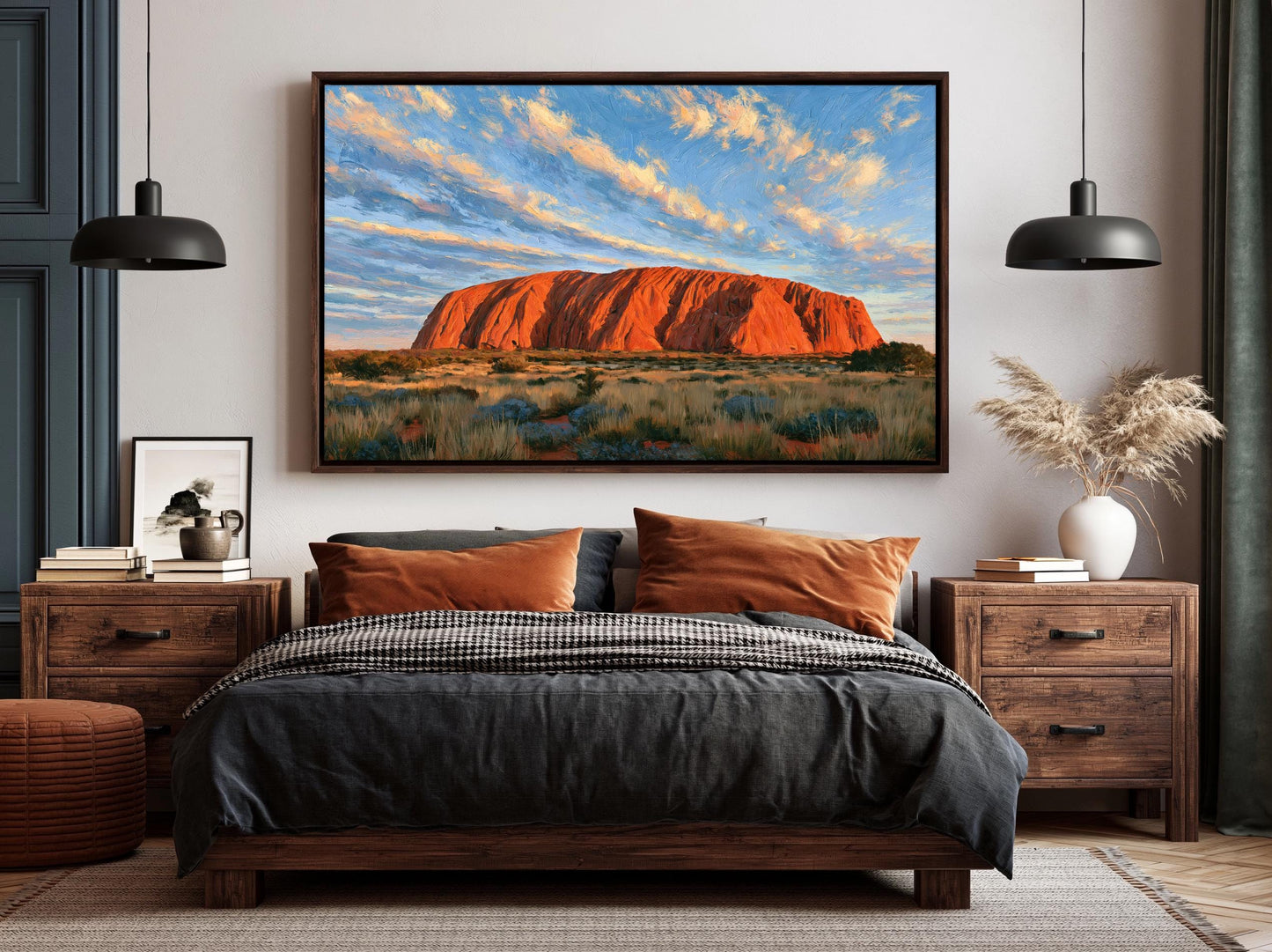 a bedroom with a large framed picture of Uluru, a famous red rock formation in Australia, hanging on the wall above a bed with a black and white checkered bedspread.
