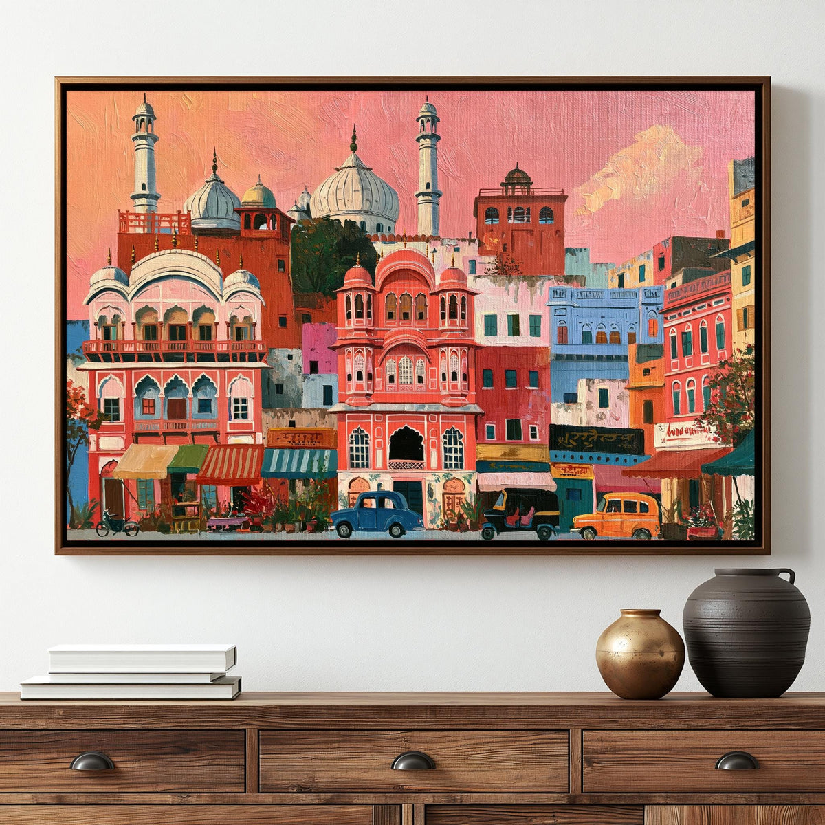 The image is a framed painting depicting a vibrant and colorful street scene in India, with a variety of buildings, vehicles, and people.
