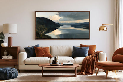 a cozy living room with a large painting of a serene landscape hanging on the wall above a white sofa adorned with throw pillows. The room is furnished with a wooden coffee table, a brown armchair, and a wooden side table with a lamp. The overall decor has a warm and inviting atmosphere, with the painting adding a touch of nature and tranquility to the space.