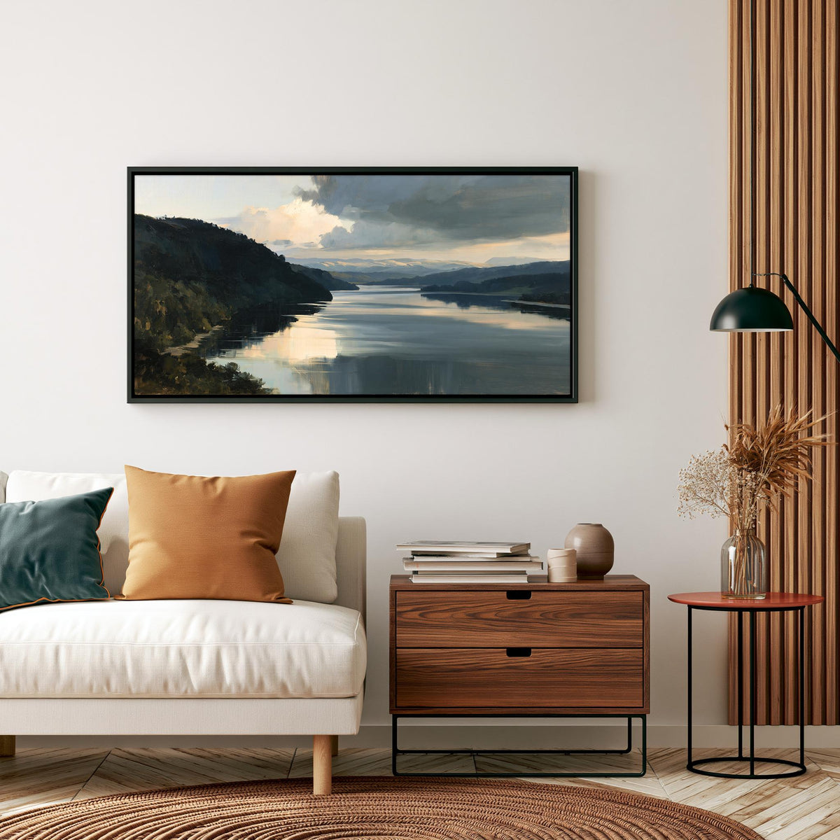 a living room with a white sofa, a wooden side table, and a framed landscape painting hanging on the wall above the sofa.