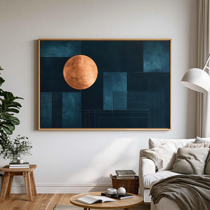 a large abstract painting hanging on a white wall in a living room. The painting has a dark blue background with a large orange circle in the center. The room has a white sofa, a coffee table, and a potted plant, creating a cozy and modern living space.