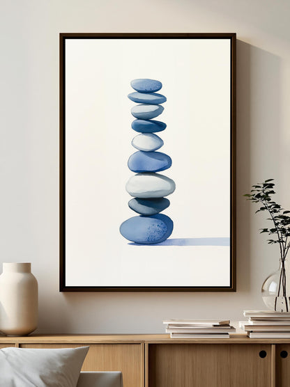 a framed painting of blue and white stones stacked on top of each other, hanging on a wall above a wooden cabinet.