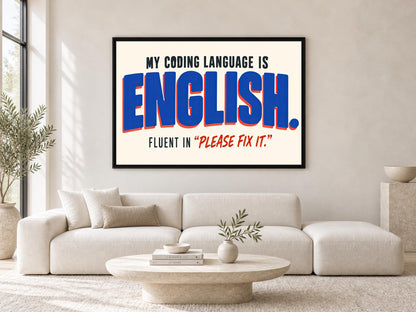 a large framed poster with the text "MY CODING LANGUAGE IS ENGLISH. FLUENT IN "PLEASE FIX IT!"" displayed on a wall above a white sofa in a living room setting.