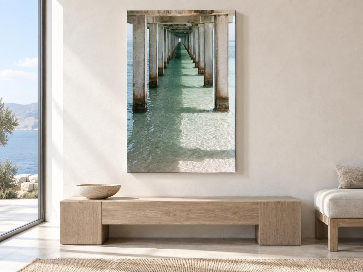 a serene indoor setting with a large window overlooking a picturesque view of a long pier extending into the water. The wooden bench in the foreground adds a touch of rustic charm to the scene. The overall atmosphere is calm and inviting, with the natural light streaming in from the window enhancing the beauty of the view.