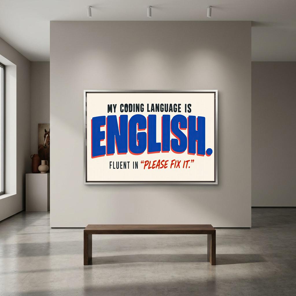 a large framed poster with the text "MY CODING LANGUAGE IS ENGLISH. FLUENT IN 'PLEASE FIX IT'".