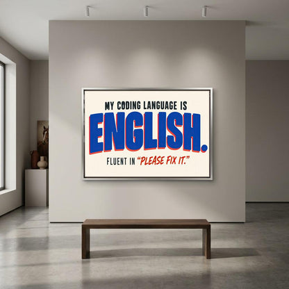a large framed poster with the text "MY CODING LANGUAGE IS ENGLISH. FLUENT IN 'PLEASE FIX IT'".
