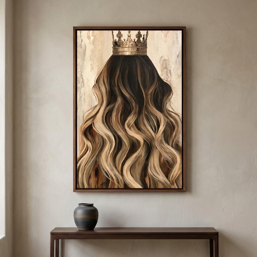 a large framed painting of a woman's long, wavy hair with a crown on top, hanging on a wall above a wooden table.