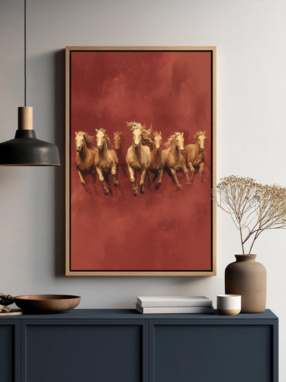 a framed painting of five horses running on a red background, hanging on a wall above a dark blue cabinet or shelf.