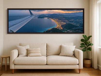 A large, framed photograph of an aerial view of a coastal city at sunset, with the city's skyline and ocean visible.