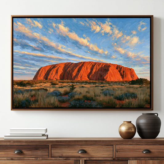a large, vibrant painting of Uluru, a famous red rock formation in Australia, hanging on a wall above a wooden dresser.