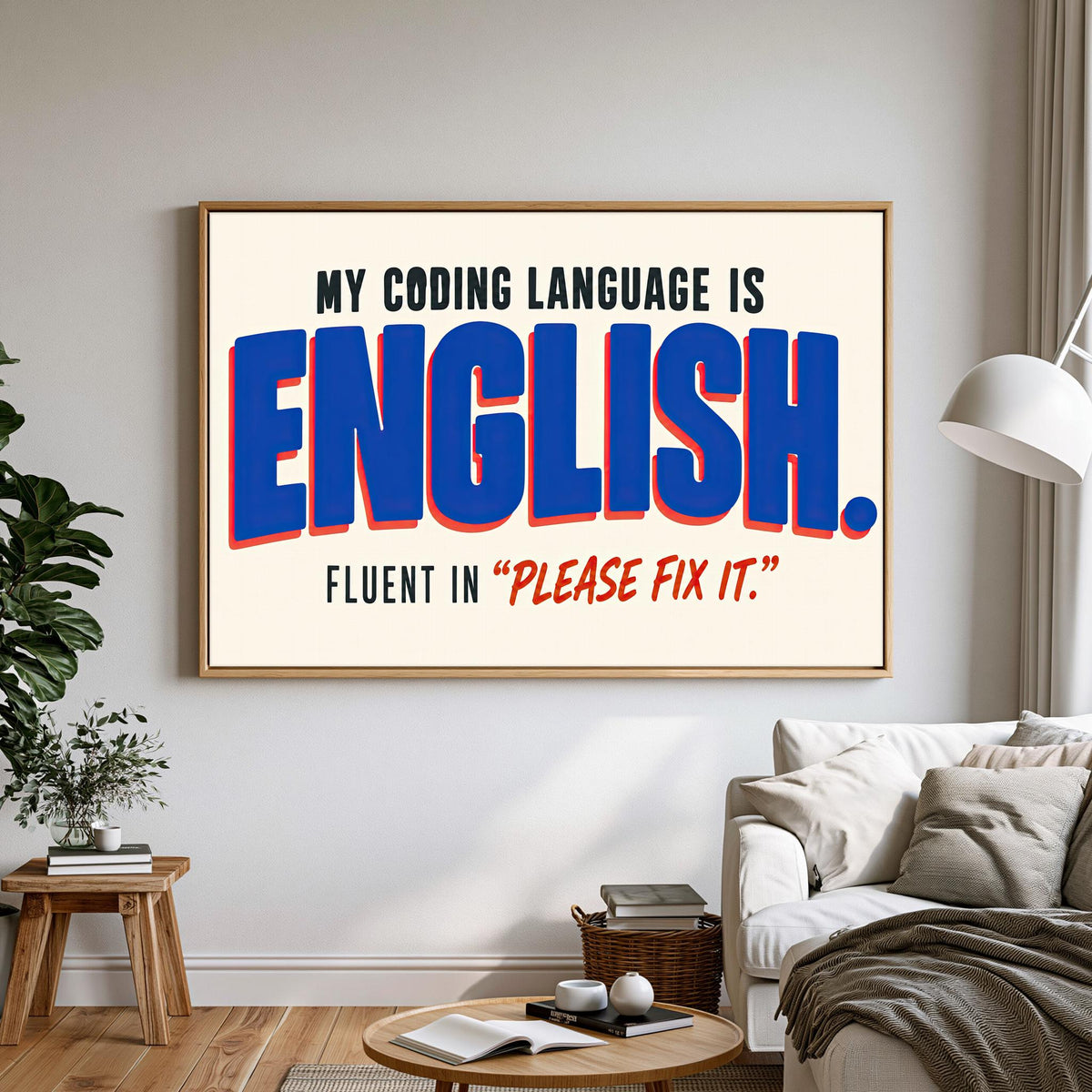 a large framed poster with the text "MY CODING LANGUAGE IS ENGLISH. FLUENT IN "PLEASE FIX IT"".