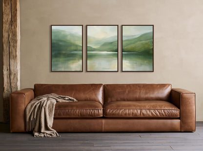 Misty sage lake triptych canvas wall art, brown leather couch with a blanket draped over it, positioned in front of a wall
