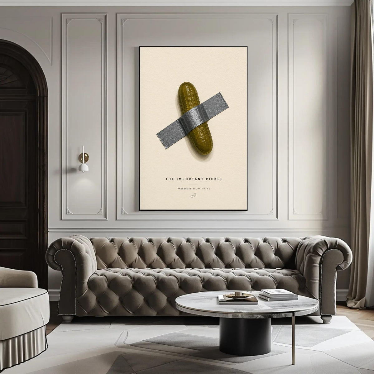 Taped pickle canvas wall art, large framed poster of a pickle taped to a wall, with a tufted gray sofa in the foreground and