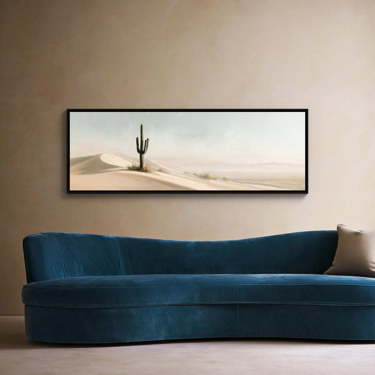 Lone saguaro on sand dunes canvas wall art, blue sofa sits against a beige wall, with a framed desert landscape painting