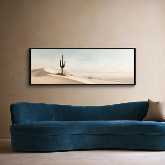 Lone saguaro on sand dunes canvas wall art, blue sofa sits against a beige wall, with a framed desert landscape painting