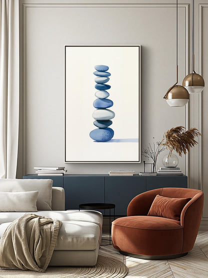 a modern living room with a large framed artwork of stacked blue and white stones on the wall, a white sofa, a red armchair, and a black side table.