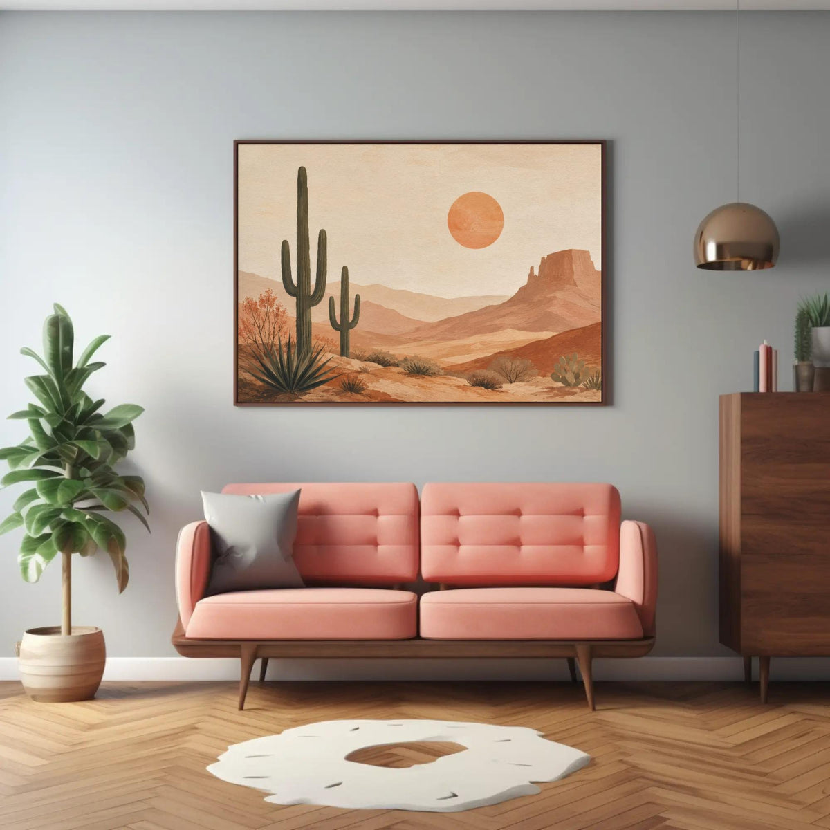 a living room with a pink sofa, a wooden dresser, and a large framed desert landscape painting hanging on the wall above the sofa.