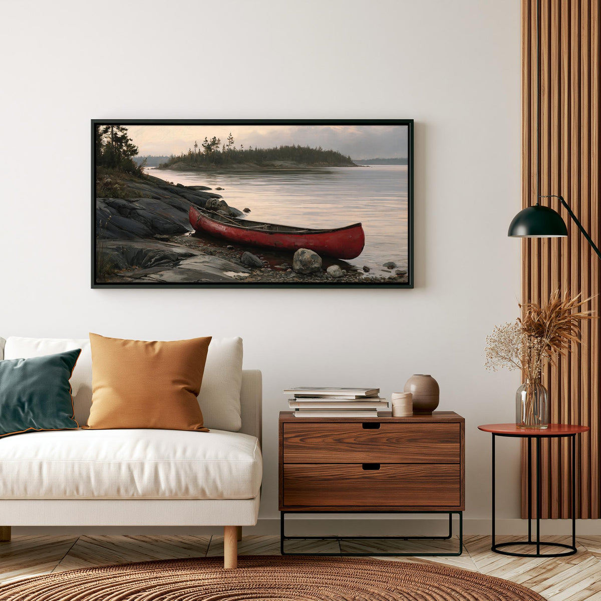 a cozy living room with a white sofa, a wooden side table, and a framed picture of a red canoe on a rocky shore.