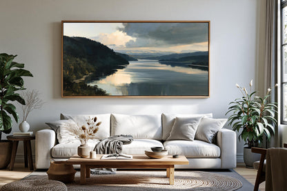 a serene living room with a large painting of a lake and mountains hanging on the wall above a white sofa. The room is decorated with potted plants, a coffee table, and a vase, creating a cozy and inviting atmosphere.