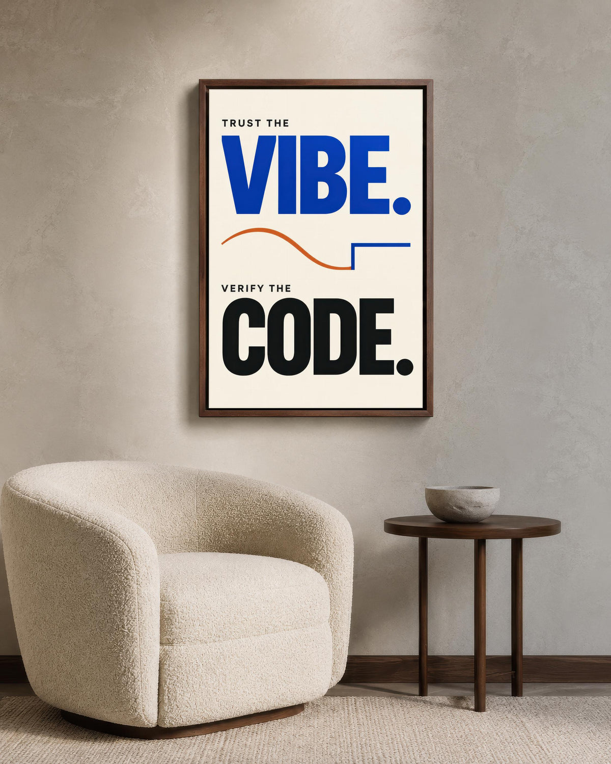 a framed poster with the text "Trust the VIBE. Verify the CODE." hanging on a wall next to a white armchair and a small round table.