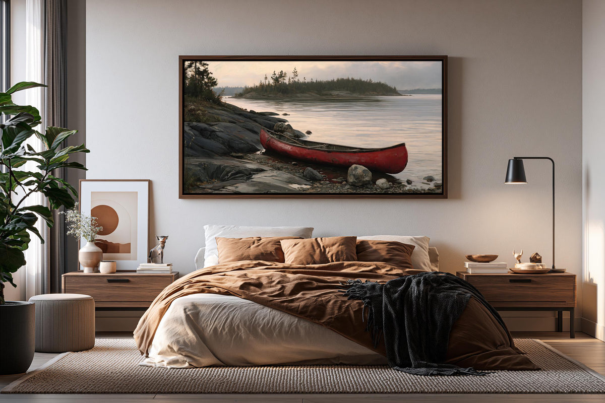 a serene bedroom scene with a large framed picture of a red canoe on the wall above a bed with a brown blanket and pillows.