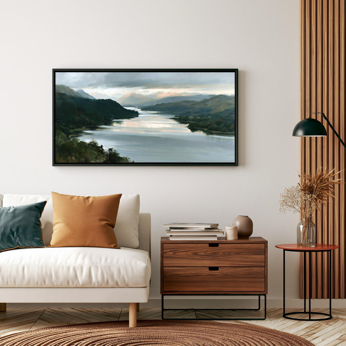 a living room with a white sofa, a wooden side table, and a framed landscape painting hanging on the wall above the sofa.