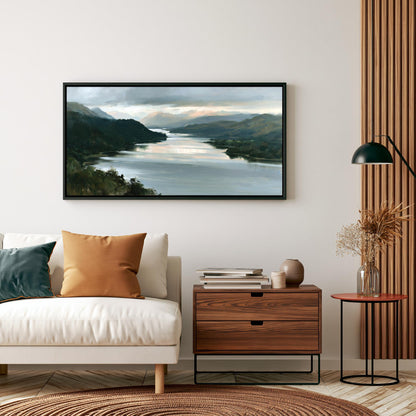 a living room with a white sofa, a wooden side table, and a framed landscape painting hanging on the wall above the sofa.