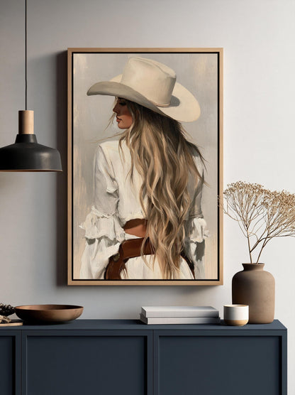 a framed painting of a woman with long blonde hair wearing a white hat, displayed on a wall above a dark blue cabinet.
