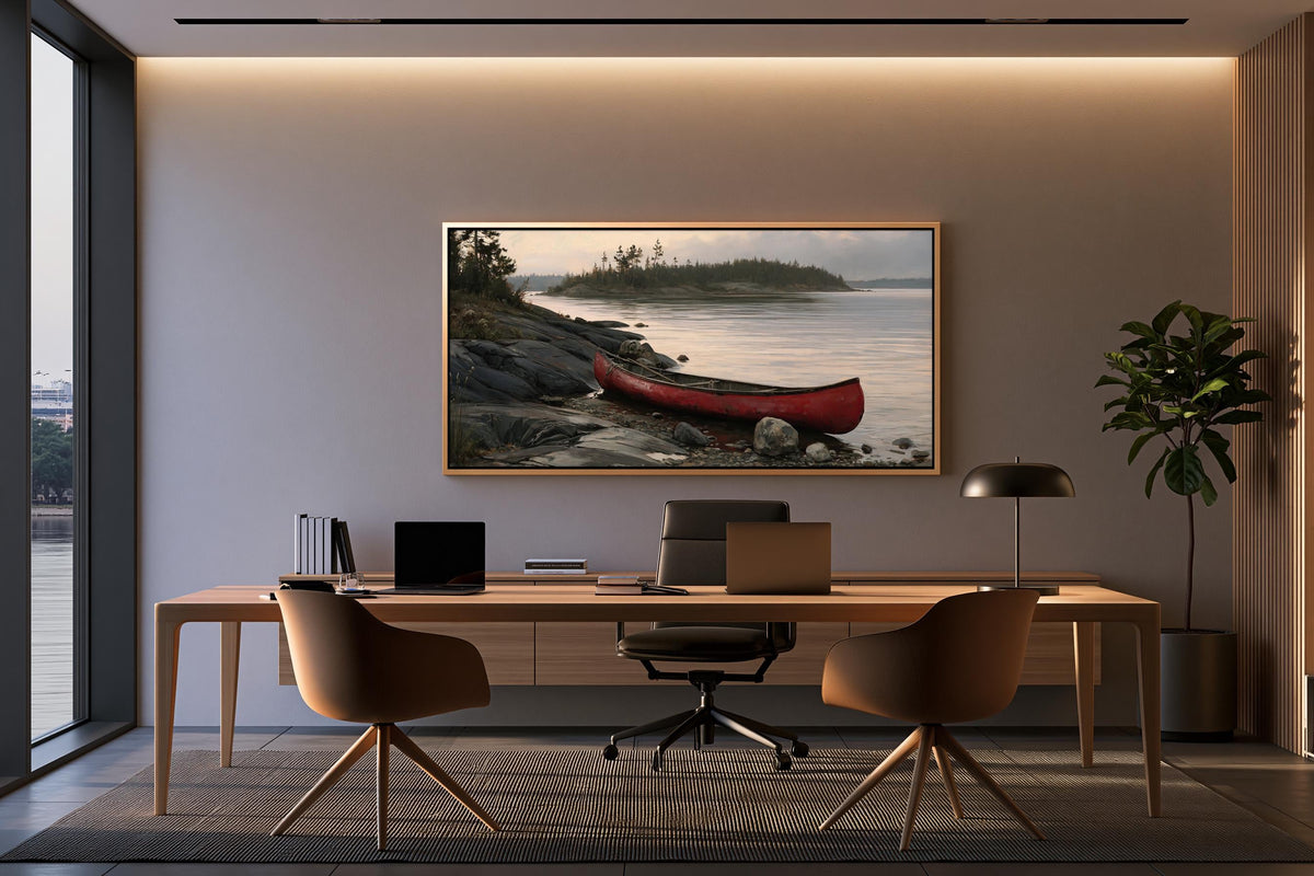 a modern office space with a large window overlooking a scenic lake. The office features a wooden desk with a laptop, a comfortable chair, and a framed painting of a red canoe on the wall.