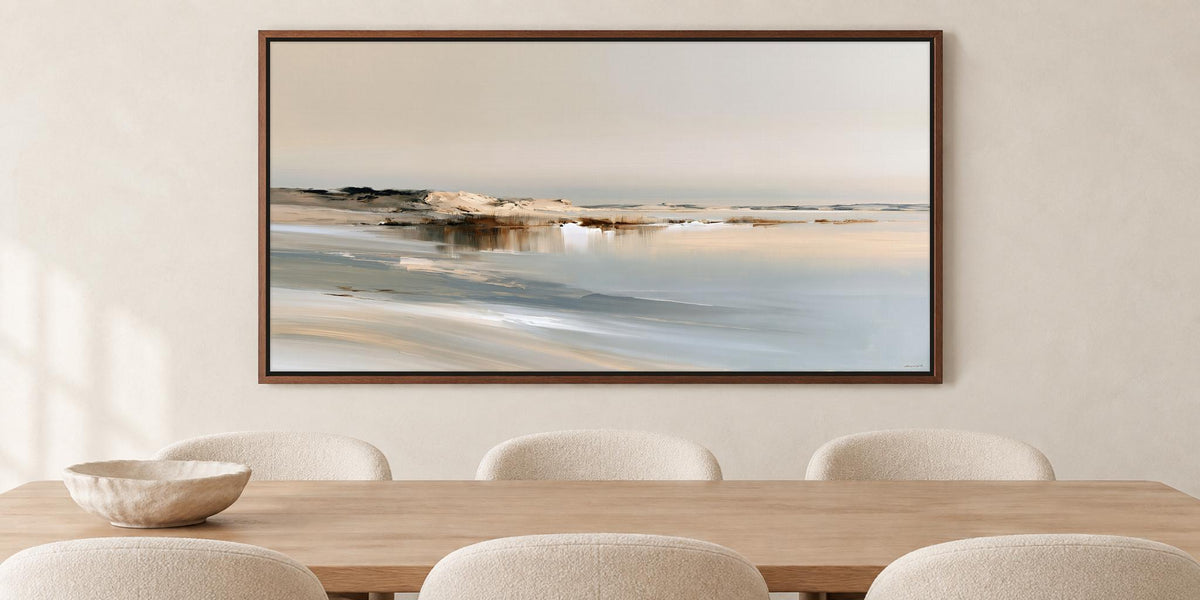 a large, framed painting of a serene landscape hanging on a wall above a wooden dining table with four white chairs.
