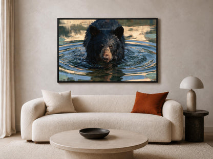 a large black bear swimming in a body of water, with a framed photograph of the bear hanging on the wall above a beige sofa in a living room setting.