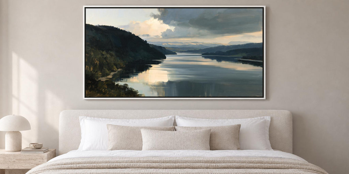 a large landscape painting hanging on a wall above a bed with white bedding.