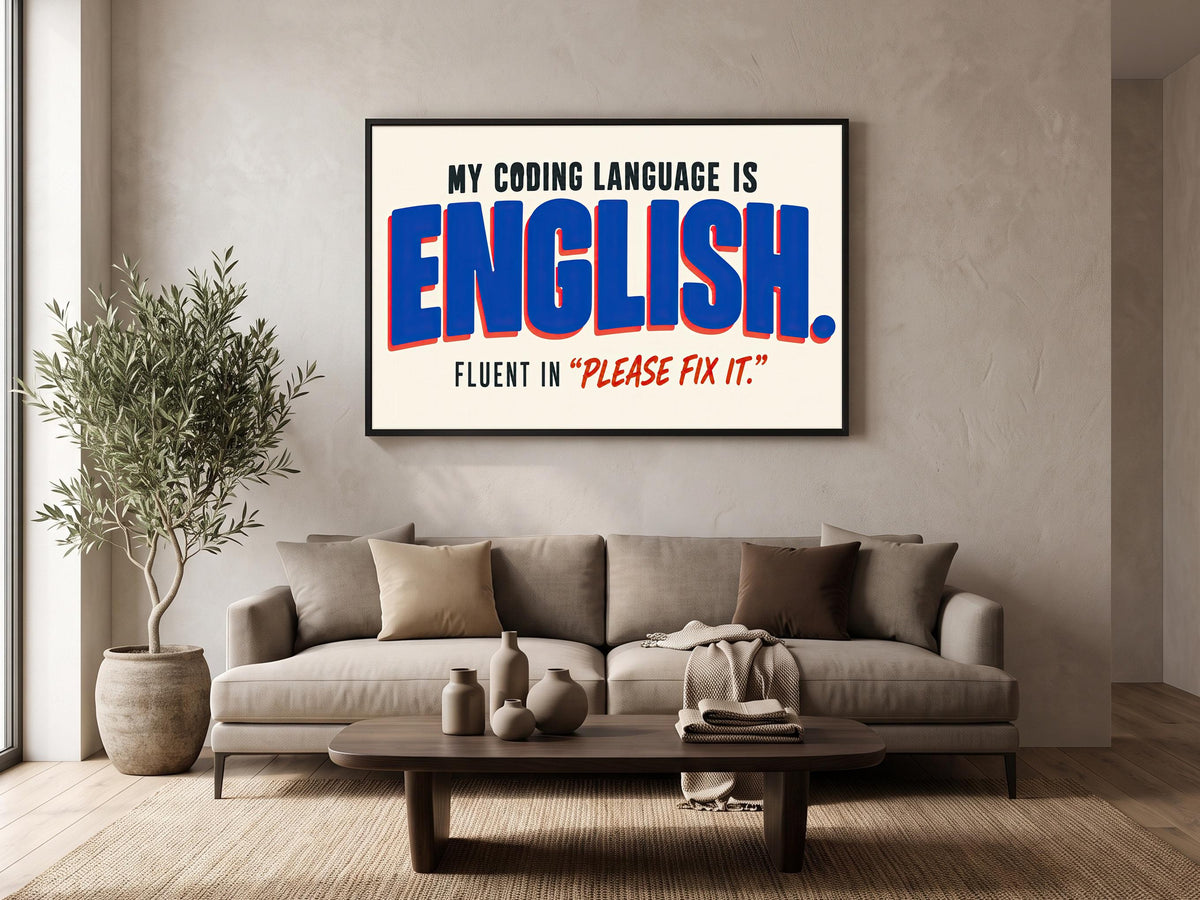 a living room with a large framed poster on the wall that reads "MY CODING LANGUAGE IS ENGLISH. FLUENT IN 'PLEASE FIX IT'". The living room has a couch, a coffee table, and a potted plant.