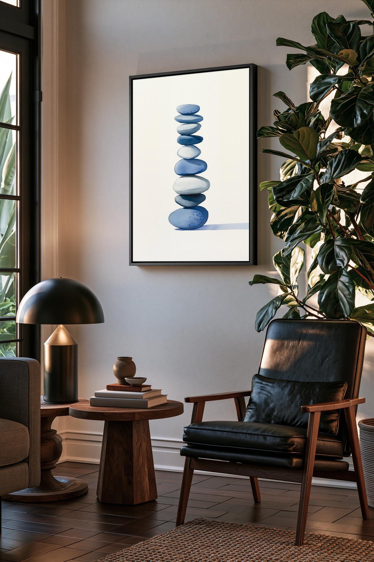 a serene living room with a wooden coffee table, a black leather armchair, and a framed artwork of stacked blue and white stones on the wall.