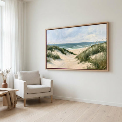 a large painting of a beach scene hanging on a white wall, with a beige armchair positioned in front of it.