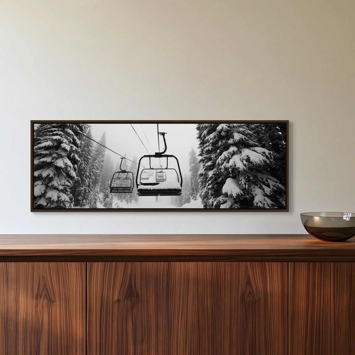 Snowy ski chairlift canvas wall art, framed black and white photograph of a ski lift in a snowy forest, hanging on a wall