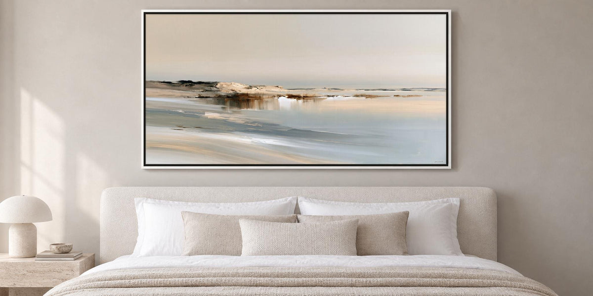 a large, framed painting of a serene landscape hanging above a bed with white bedding and pillows.