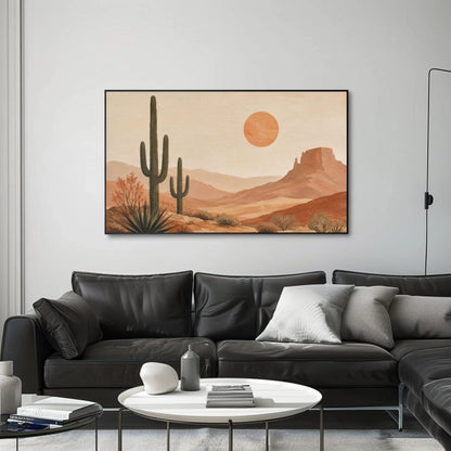 a large framed painting of a desert landscape with cacti and mountains in the background, hanging on a wall above a black leather couch in a living room setting.