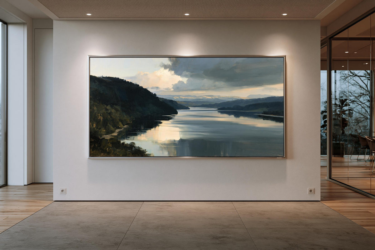 a large, framed painting of a serene landscape depicting a calm lake surrounded by mountains.