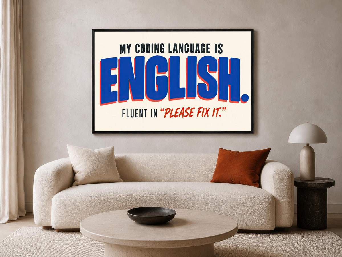 a living room with a large framed poster on the wall that reads "MY CODING LANGUAGE IS ENGLISH. FLUENT IN "PLEASE FIX IT".