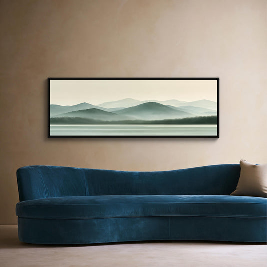 Sage green misty mountains canvas wall art, large, framed landscape painting hanging on a beige wall above a blue velvet sofa