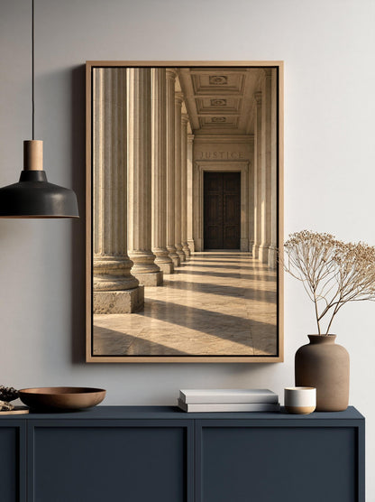 a framed photograph of a classical architectural hallway with columns and a door, hanging on a wall above a dark blue cabinet.