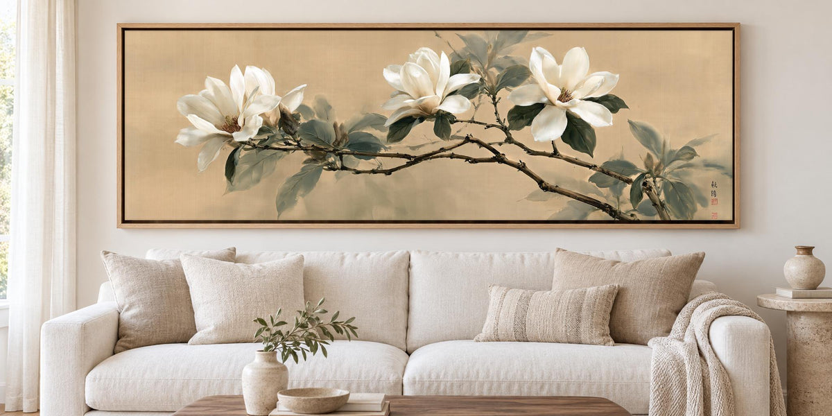 a large painting of white flowers on a wall above a white sofa with beige pillows.