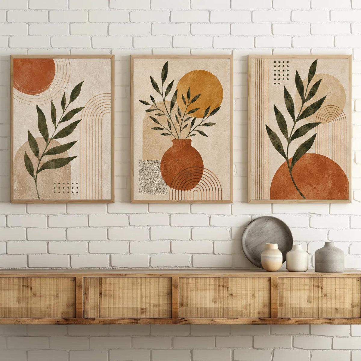 Boho botanical abstract trio canvas wall art, three framed artworks displayed on a white brick wall above a wooden shelf.