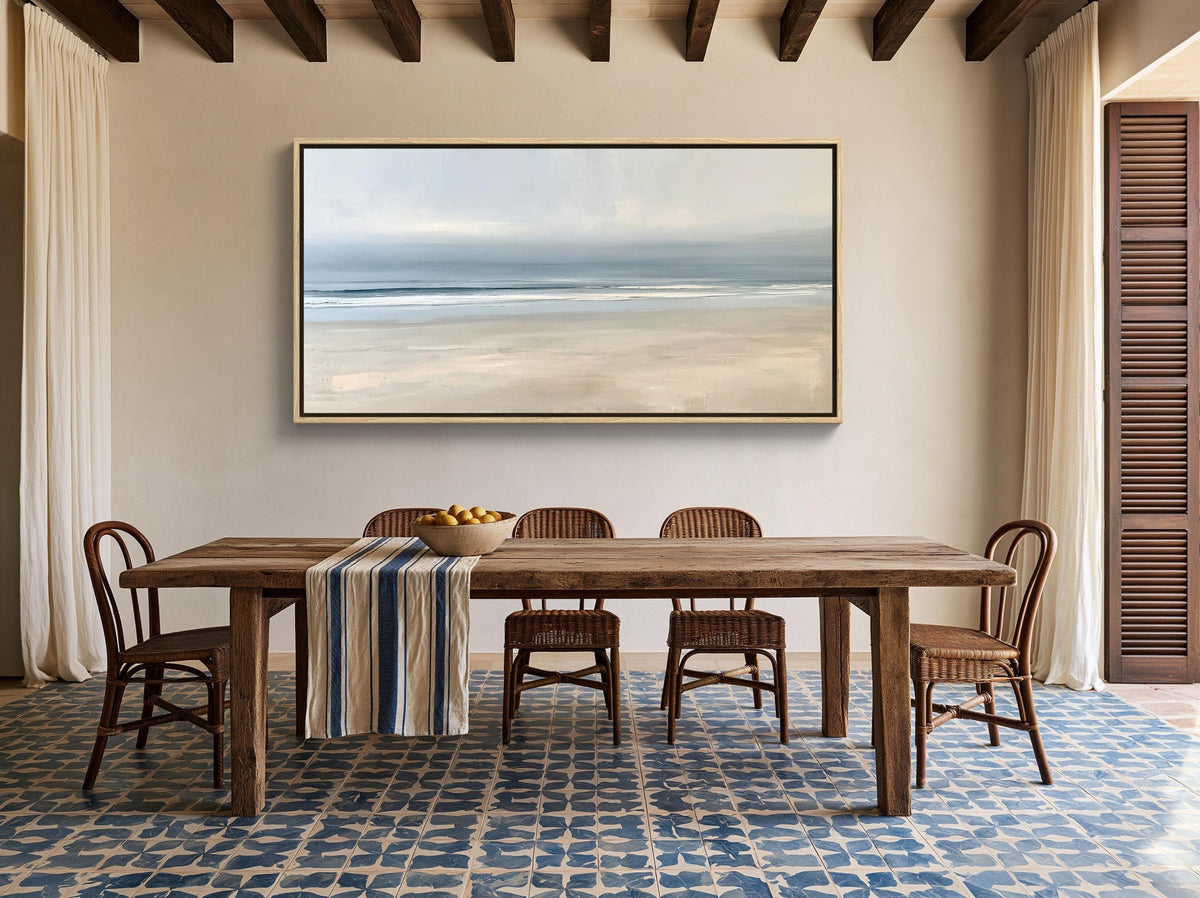 Calm minimalist beach canvas wall art, dining room with a large wooden table and four chairs. Above the table, there is a