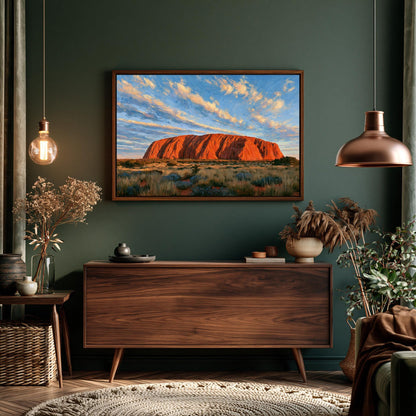a large wooden dresser with a framed picture of Uluru, a famous red rock formation in Australia, hanging above it. The dresser is situated in a room with a green wall, and there are potted plants and other decorative items on the floor.