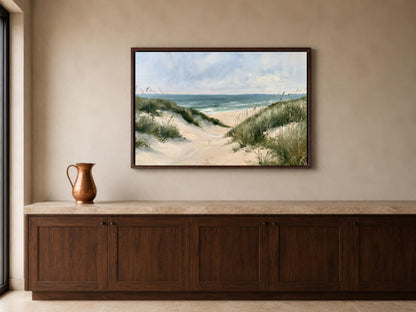 a large framed painting of a beach scene hanging on a wall above a wooden cabinet or counter.